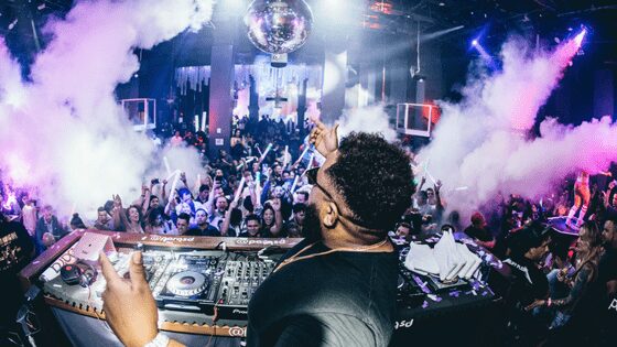People dancing and a DJ in a night club