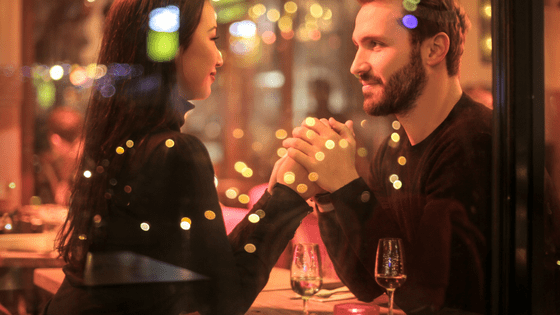 a couple holding hands in a restaurant