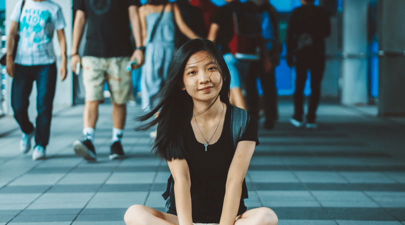 Thai girl sitting on the sidewalk