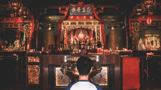 an Indonesian man praying in temple